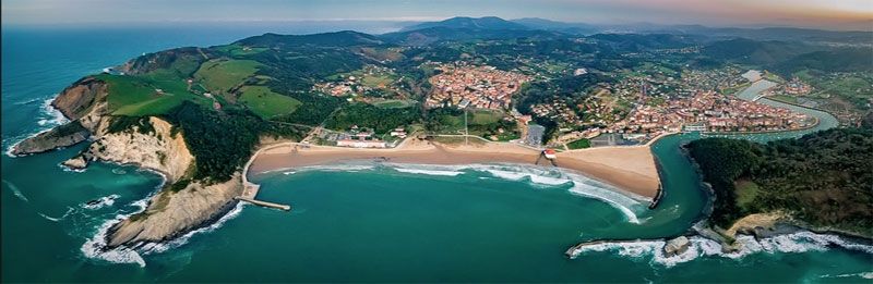 Imagen panorámica de la playa de Gorliz, destacando su amplio y sereno paisaje costero. La imagen invita a los lectores a sumergirse visualmente en el entorno natural de Gorliz mientras exploran las actividades familiares que ofrece este encantador destino vacacional.